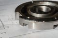 The transition flange after processing lies on the technical drawing. Detail ready to work with a drawing together in mechanical Royalty Free Stock Photo