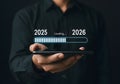 Transitioning to the new year concept of loading bar from year 2025 to 2026 on a mobile phone Royalty Free Stock Photo