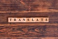 Translate word lettering made of wooden cubes on dark rustic wooden background. Multilingual online translator, business and