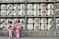 Translation: girls in kimono in front of drums or barrels of sake (Japanese alcoholic drinks) at Tsurugaoka shrine