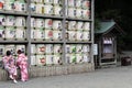 Translation: girls in kimono in front of drums or barrels of sake (Japanese alcoholic drinks) at Tsurugaoka shrine Royalty Free Stock Photo