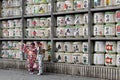 Translation: girls in kimono in front of drums or barrels of sake (Japanese alcoholic drinks) at Tsurugaoka shrine Royalty Free Stock Photo