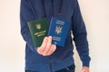 Translation: military id. Civil man in blue sweatshirt with ukrainian foreign passport and army document