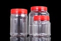 Translucent plastic PVC jar with red cover isolated in black