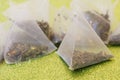 Translucent pyramid tea bags with green tea, lemon and mint slices on a shiny golden surface. The drink of the long-lived. Macro, Royalty Free Stock Photo