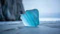 Translucent turquoise glacier ice chunk with blue striations and melting droplets Royalty Free Stock Photo