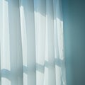 Translucent white curtains hang in front of a window, allowing soft sunlight to filter Royalty Free Stock Photo