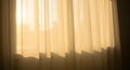Translucent white curtains hang from a window, gently illumin Royalty Free Stock Photo