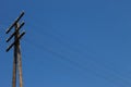 Transmission lines. Old wooden pillar of an electric line against a blue sky background Royalty Free Stock Photo