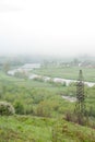 Transmission tower. Giant cloud. Bridge over river. Foggy weather. Carpathians, Ukraine.