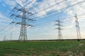 Transmission tower overhead line masts, a lot of high-voltage power line, high voltage pylons also known as power pylons on the fi Royalty Free Stock Photo