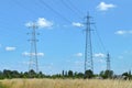 Transmission towers carrying high voltage electric power lines. Electricity pylons in the field Royalty Free Stock Photo