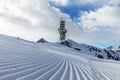 A transmitter at the top of a mountain in the Dolomites ski area. Empty ski slope in winter on a sunny day. Prepare ski slope, Alp