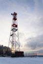 Transmitters and aerials on telecommunication tower, sunset in snowy country Royalty Free Stock Photo