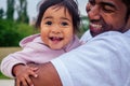 Transnational interracial afro father spinning around circles at the park mixed race baby girl