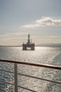 Transocean Leader oil platform at Invergordon during sunset, cruise ship railing in front, vertical shot Royalty Free Stock Photo