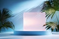 Transparent acrylic cylindric pedestal with tropical palm leaf on minimal blue background