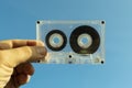 Transparent audio cassette in hand
