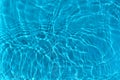 Transparent blue clear water surface texture with ripples, waves and rings in sunlight. Royalty Free Stock Photo