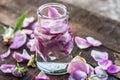 A transparent bottle contains rose water with rose petals in it Royalty Free Stock Photo