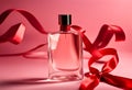 Transparent bottle of perfume with ribbon bow on a red background Royalty Free Stock Photo