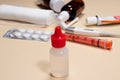 Transparent bottle with a red lid on the background of other cures on a beige background. Medicine and Pharmacy layout