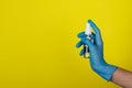 Transparent bottle of sanitizer on a yellow background in the female hand