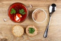 Transparent bowl with borscht, jar with liver pate, bread, sandwich with meat pate, spoon on table. Top view