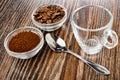 Bowls with ground coffee and roasted coffee beans, spoon, coffee cup on wooden table Royalty Free Stock Photo