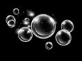 Transparent bubbles floating on a black background with sparkling stars Royalty Free Stock Photo