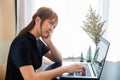 transparent businesswoman dressed in black uses a laptop to work stressfully