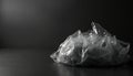 Transparent cellophane bag on dark surface. Clear plastic packaging against black background. Studio shot of crumpled plastic Royalty Free Stock Photo