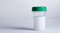 Transparent clean urine analysis container with a green lid. Clear specimen cup on a white background. Concept of