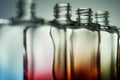 Transparent colored bottles for perfume or drinks on a gradient light background. Without cover. Selective focus. For an article Royalty Free Stock Photo