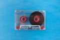 Transparent compact audio cassette isolated on blue background. To Royalty Free Stock Photo