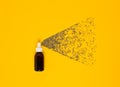 Transparent cosmetic amber glass spray bottle on a yellow background. Lavender flowers scatter like small droplets from a spray.