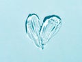 Transparent cosmetic gel heart shape on blue bg