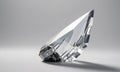 transparent crystal sculpture with pointed apex and reflective surface is displayed against gray background. Royalty Free Stock Photo
