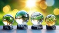 Transparent crystal spheres filled with sunlight on on stone pedestals. Green trees and landscapes are reflected the