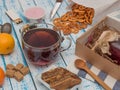 Transparent cup of black tea, crackers, jam and lemon on a wooden table