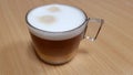 Transparent Cup of cappuccino on a wooden table