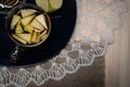 Transparent cup of tea with apples. Look over the top. It stands on a lace cloth and linen tablecloth.