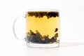 Transparent cup of tea with custard on white background