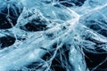 Transparent dark blue ice of frozen Baikal lake with white cracks pattern. Royalty Free Stock Photo