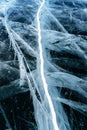 Transparent dark blue ice of frozen Baikal lake with white cracks pattern. Royalty Free Stock Photo