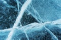 Transparent dark blue ice of frozen Baikal lake with white cracks pattern. Royalty Free Stock Photo