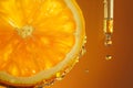 Transparent drop of serum and oil falling from pipette with Vitamin C, orange slice