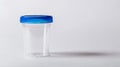 Transparent empty urine analysis container with a blue lid. Clear specimen cup on a white background. Concept of