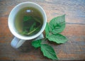 freshly brewed raspberry leaf tea in a white cup and a fresh raspberry leaf Royalty Free Stock Photo