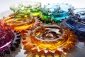 Transparent gear wheels filled with colorful, swirling liquid, showcasing a dynamic and creative industrial concept